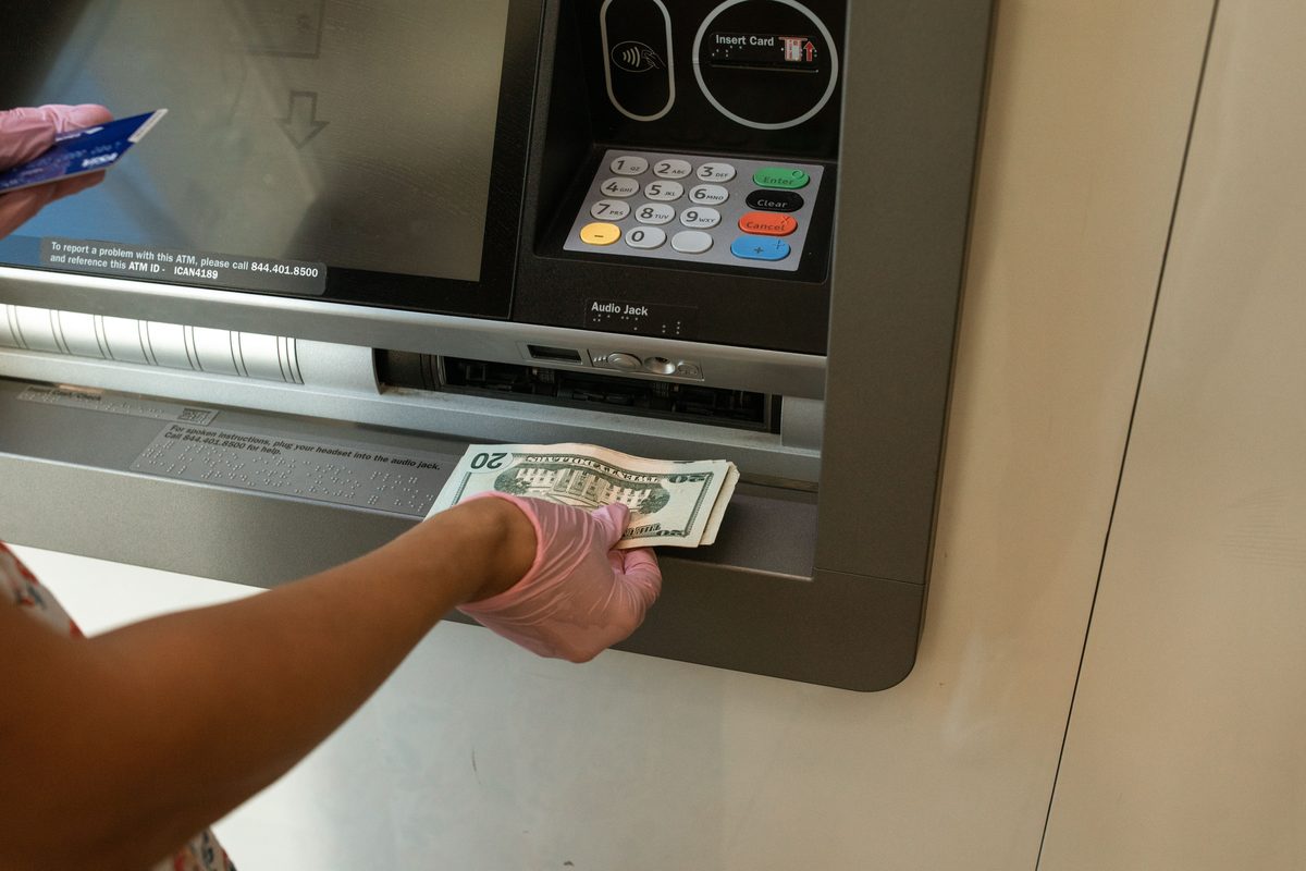 Person withdrawing cash at ATM with debit card - Cash App Direct Deposit and banking access